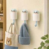 Three squirrel wall hooks holding a tote bag and a beanie